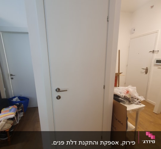 דלת לבנה עם ידית מתכת בחדר פנימי
